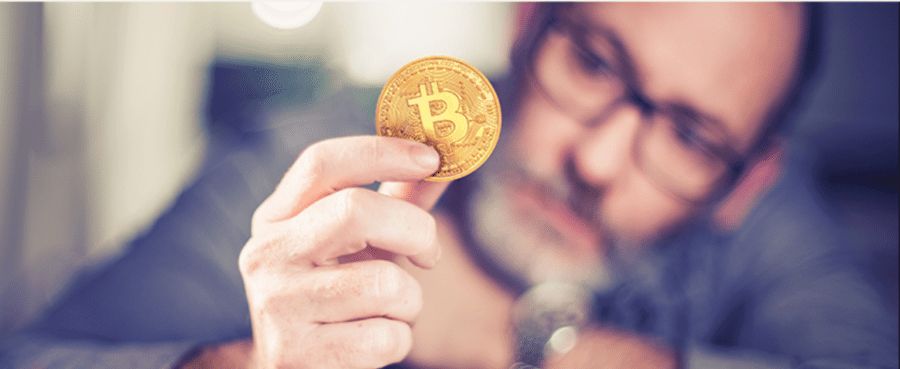 hombre sosteniendo un bitcoin